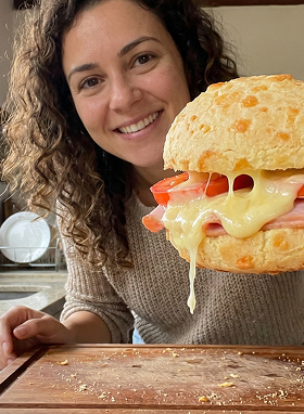 Cliente mostrando lanche com queijo derretido